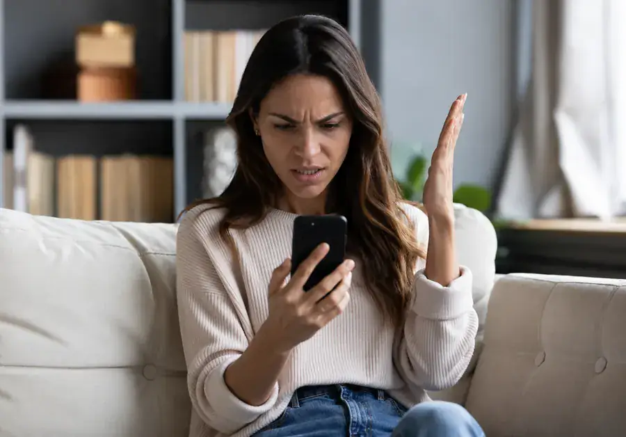 Profissional sobrecarregada no celular — o verdadeiro inimigo é a conversa sem estratégia